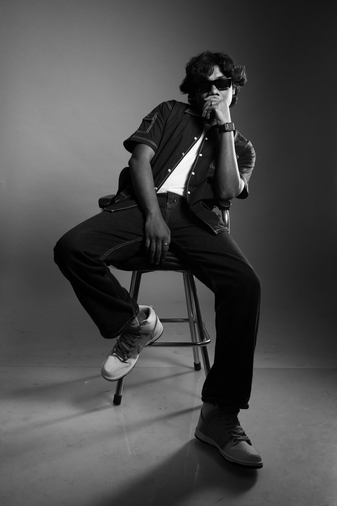Black and white portrait of Devoid seated wearing sunglasses